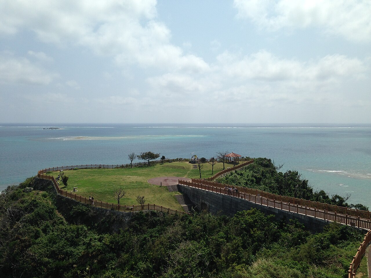 海に突き出た芝生の台地と赤瓦の東屋が見える知念岬公園（写真：そらみみ / CC BY-SA 4.0）